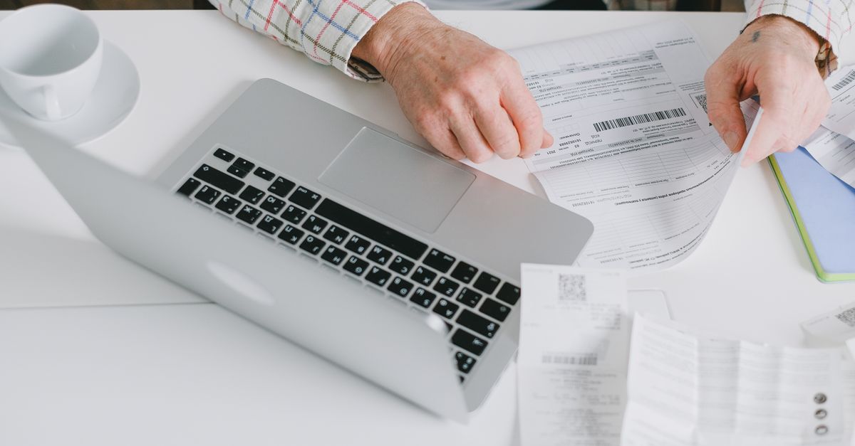 Manos desarmando una notebook sobre una mesada de trabajo con herramientas